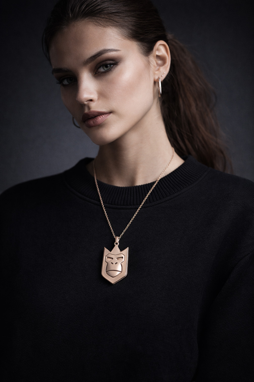 Editorial portrait of a woman wearing the QueenQong rose-gold crowned-mask pendant